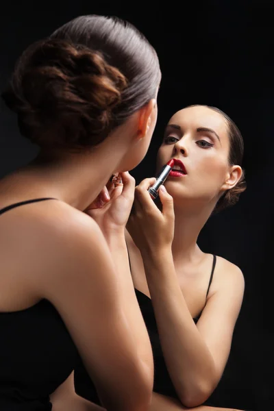 Vacker ung kvinna nära spegel med läppstift — Stockfoto