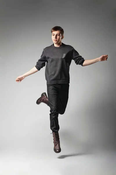 Young fashion male jumping on grey background — Stock Photo, Image