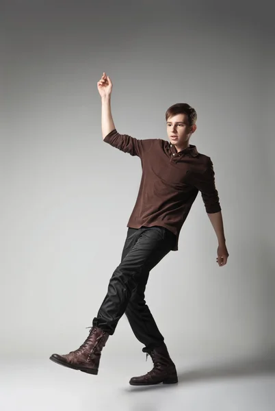 Jonge mode man springen op grijze achtergrond — Stockfoto