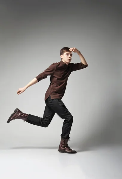 Young fashion male jumping on grey background — Stock Photo, Image