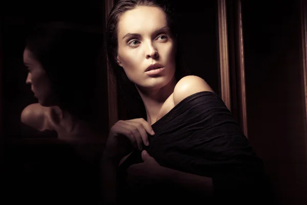 Piękna młoda kobieta w pobliżu szkła we wnętrzu — Zdjęcie stockowe