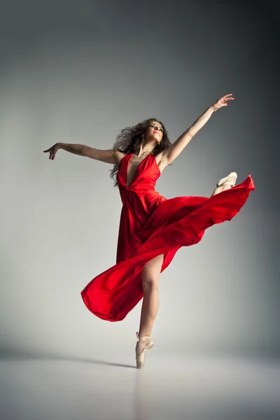 Dançarina de balé vestindo vestido vermelho sobre cinza — Fotografia de Stock