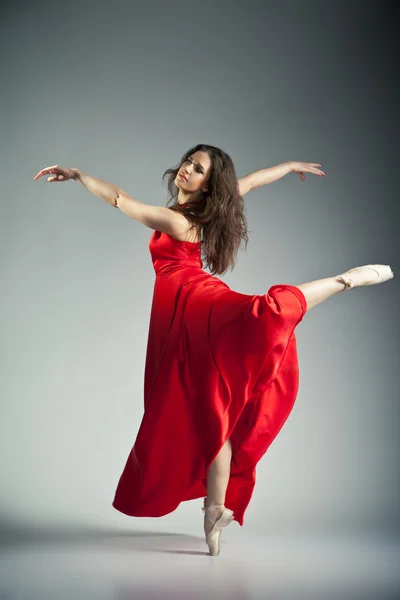 Ballet dancer wearing red dress over grey — Stock Photo, Image