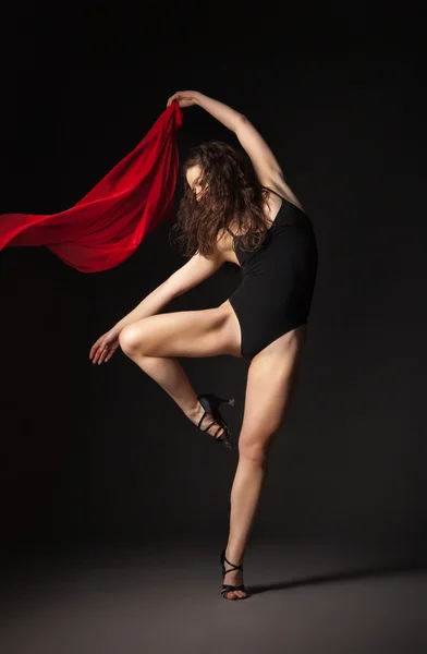 Dançarino moderno com tecido vermelho posando em cinza — Fotografia de Stock