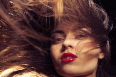 Kırmızı dudaklar ve akan saç genç kadın