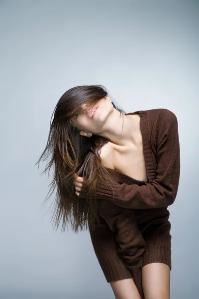 Attraktive lächelnde Frau mit langen Haaren auf grau — Stockfoto