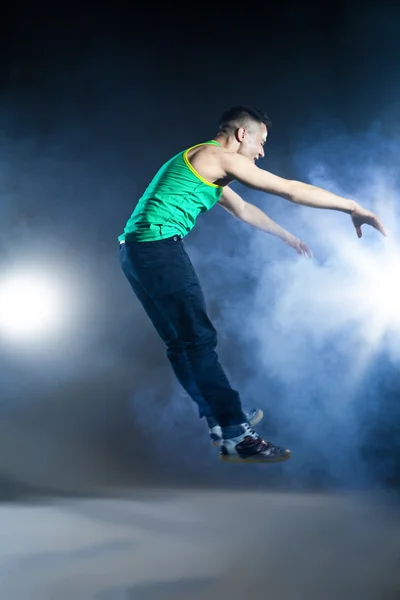 Danser die zich voordeed op achtergrond met flitsen en rook — Stockfoto