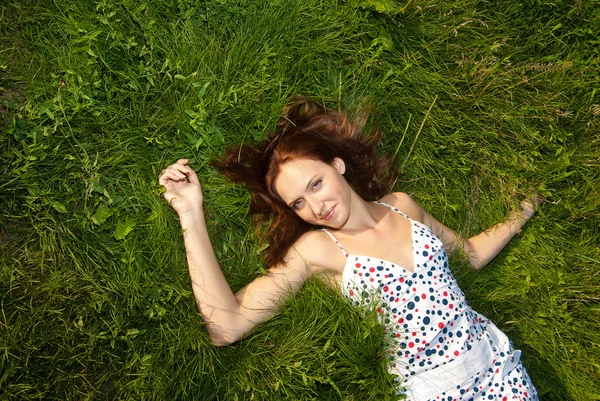 Kobieta szuka szczęśliwa i uśmiechnięta na trawie — Zdjęcie stockowe