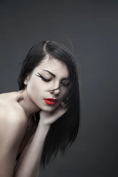 Brunette woman with long straight hair on dark — Stock Photo, Image