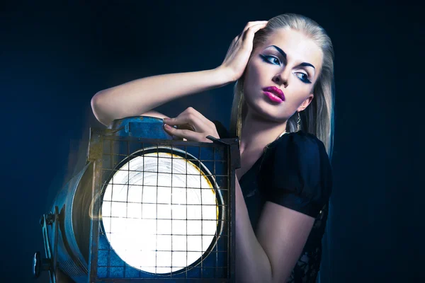 Sexy young woman with old floodlight — Stock Photo, Image