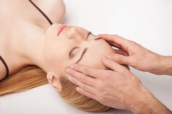 Jeune femme recevant un massage de la tête sur blanc — Photo