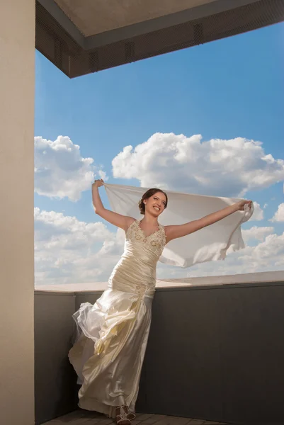 Happy beautiful bride with flying fabric over sky — Stock Photo, Image