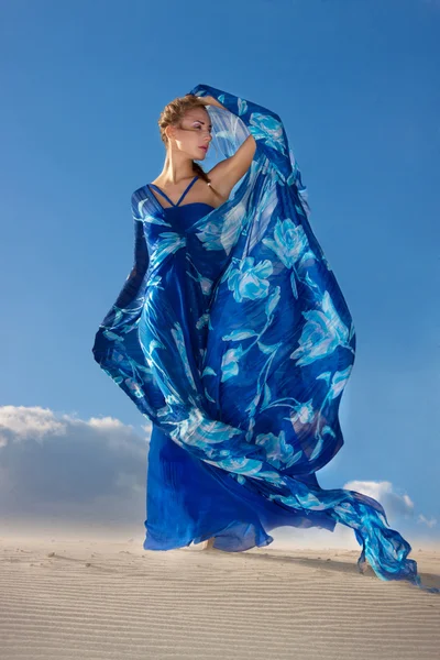 Mulher de beleza em vestido azul no deserto — Fotografia de Stock