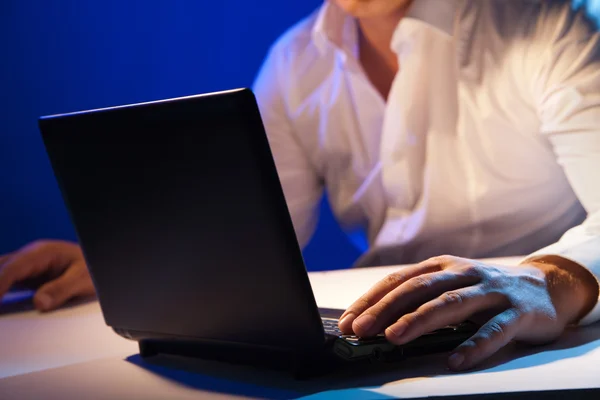 Businessman working on laptop over dark — Stock Photo, Image