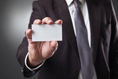 İş adamı koyu gri arka plan üzerinde kartı göster