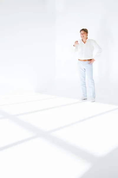 Attractive man having a tea, standing on white — Stock Photo, Image