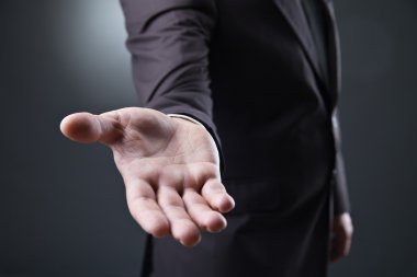 Koyu arka plan üzerinde boş el ile iş adamı