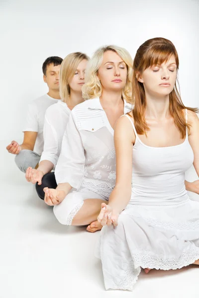 Group of people relaxing and doing yoga in white — Stock Photo, Image