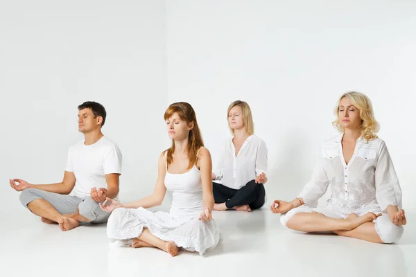 Group of people relaxing and doing yoga in white — Stock Photo, Image