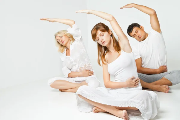 Gruppe von Menschen, die sich entspannen und Yoga in Weiß machen — Stockfoto