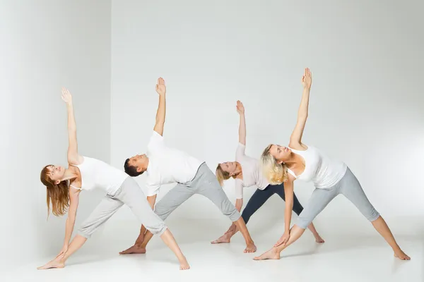 Grupper av mennesker som slapper av og gjør yoga i hvitt – stockfoto