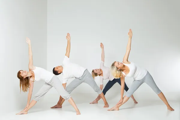 Group of people relaxing and doing yoga in white — Stock Photo, Image