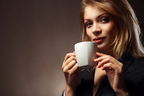 Красивая девушка пьет чай или кофе — стоковое фото