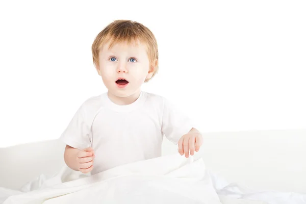 Schattige babymeisje in bed thuis enthousiast over Wit — Stockfoto