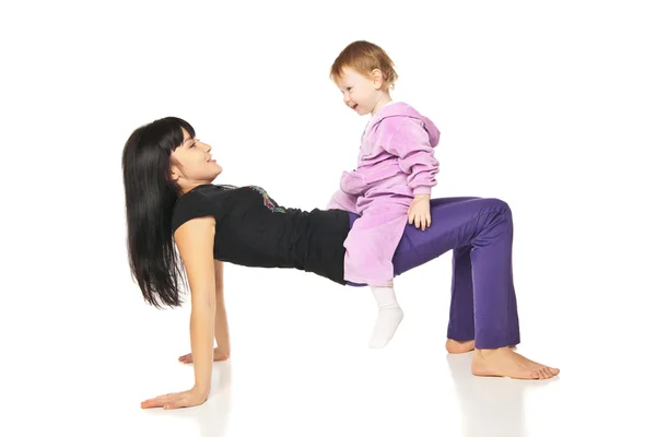 Madre con el bebé haciendo ejercicios sobre blanco — Foto de Stock