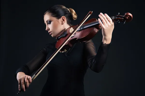 Schöne junge Frau spielt Geige über Schwarz — Stockfoto