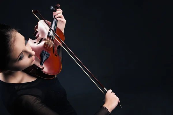 Beautiful young woman playing violin over black — Stock Photo, Image