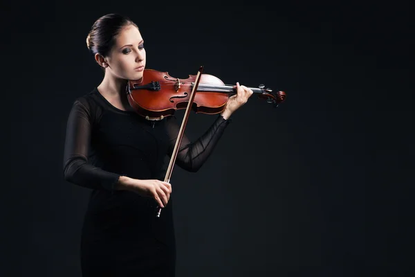 Beautiful young woman playing violin over black — Stock Photo, Image