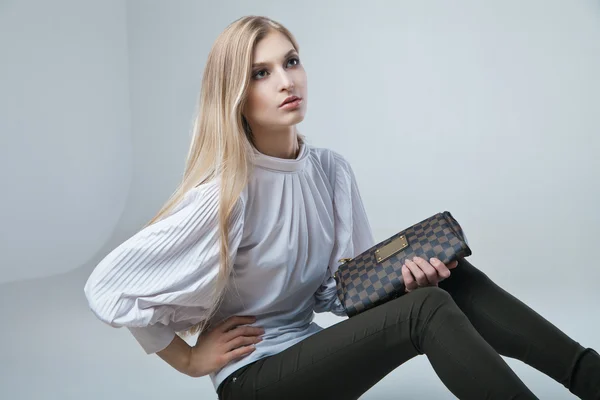 La mujer a la moda con la bolsa en el fondo claro —  Fotos de Stock