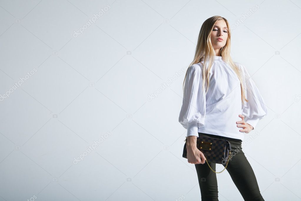 Fashionable woman with a bag in light background