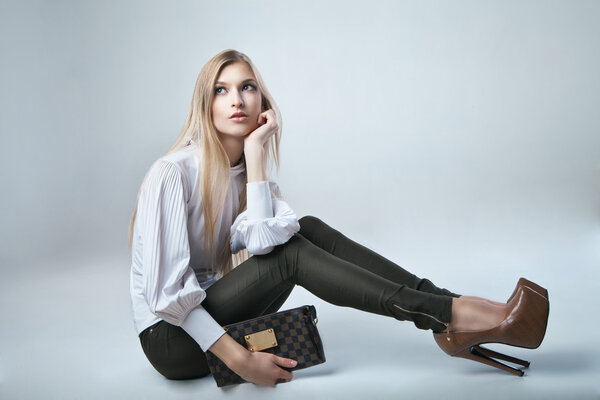 Модная женщина с сумкой на светлом фоне
