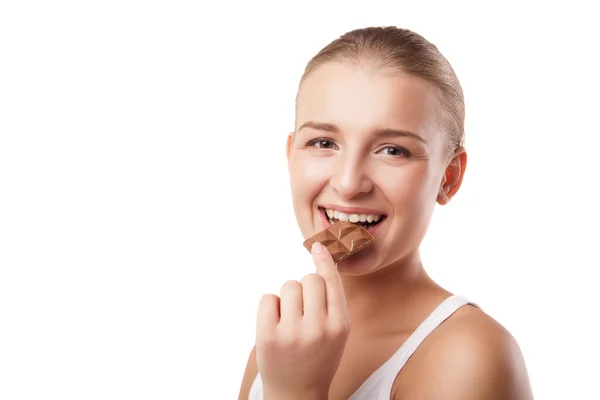 Blonde jonge vrouw bijten chocolade geïsoleerd — Stockfoto