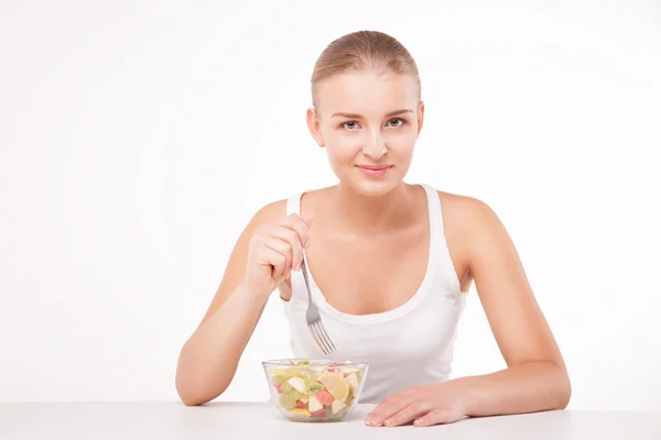 Ładna dziewczyna, jedzenie na białym tle sałatka owocowa — Zdjęcie stockowe