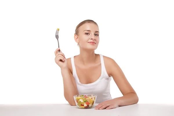 Menina bonita comer salada de frutas isolado — Fotografia de Stock