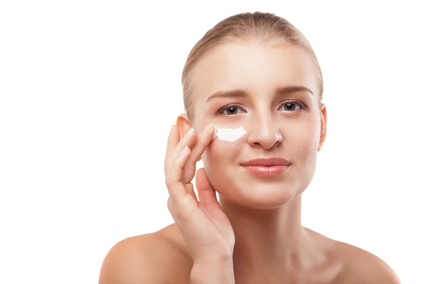 Mujer aplicando crema hidratante en la cara aislada — Foto de Stock