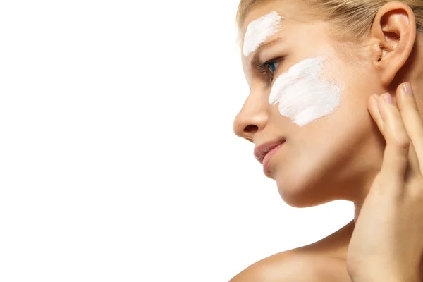 Frau trägt Feuchtigkeitscreme auf Gesicht isoliert auf — Stockfoto