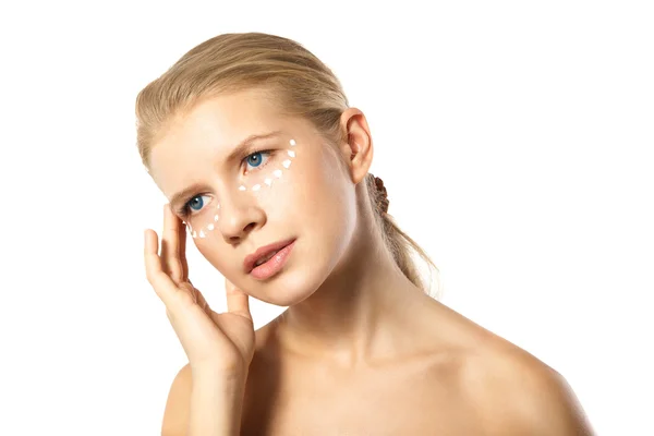 Vrouw toepassing moisturizer crème op gezicht geïsoleerd — Stockfoto