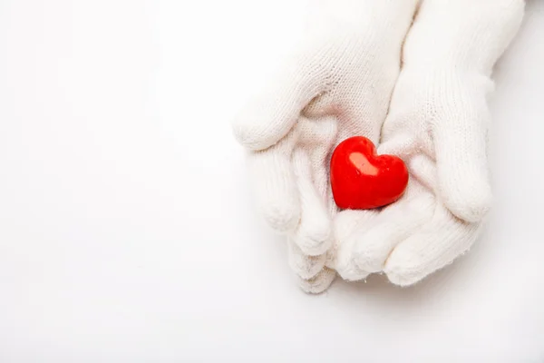 Woman hands in white gloves holding heart symbol — Stock Photo, Image