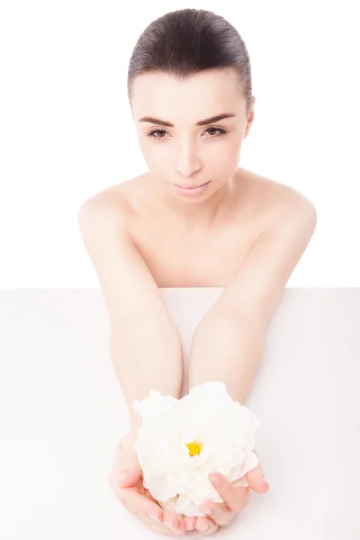 Jovem mulher bonita relaxando com flor no spa — Fotografia de Stock
