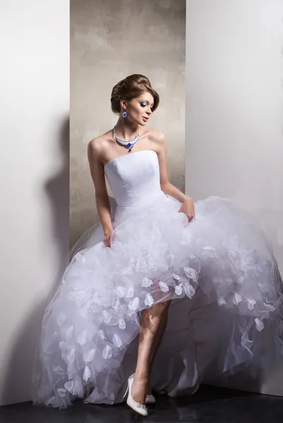 Kvinna poserar i en bröllopsklänning Royaltyfria Stockfoton