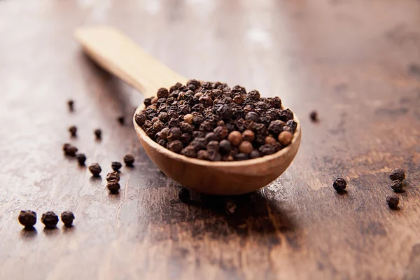 Pepper in an old wooden spoon. Spices — Stock Photo, Image