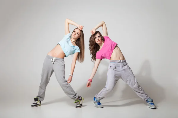 Cool op zoek twee dansende vrouwen op grijze achtergrond — Stockfoto