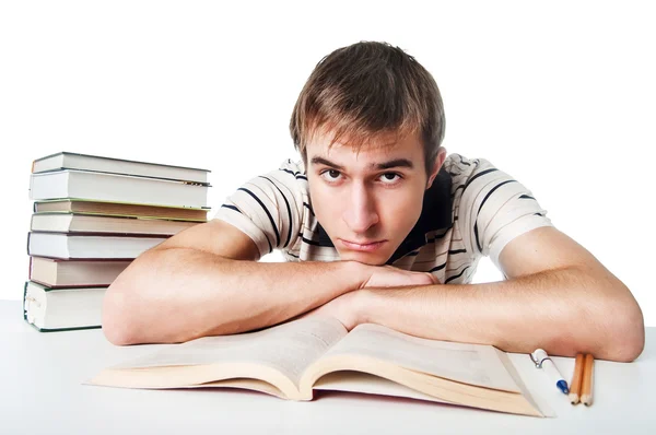 Estudante masculino na mesa com pilha de livros — Fotografia de Stock