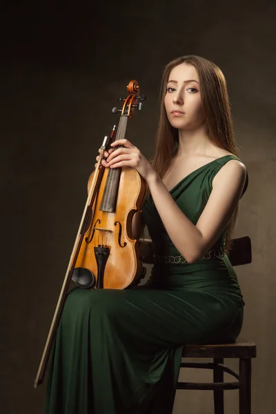 Beautiful young woman playing violin over black — Stock Photo, Image