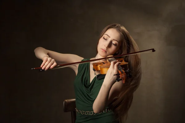 Beautiful young woman playing violin over black — Stock Photo, Image