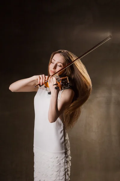 Schöne junge Frau spielt Geige über Schwarz — Stockfoto
